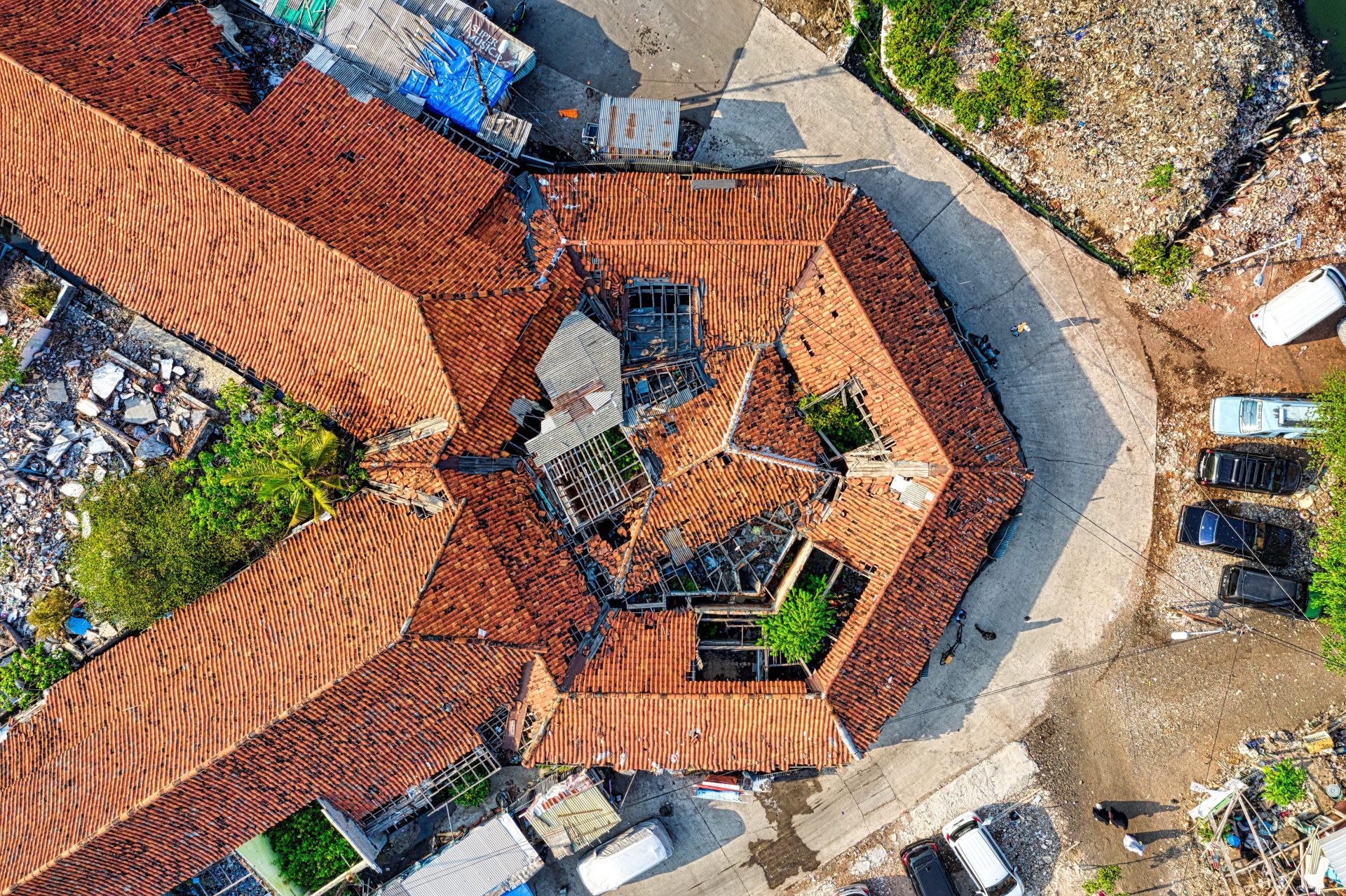 Luftaufnahme einer Drohne, die ein Dach in Jakarta zeigt – mit einem einzigartigen architektonischen Design und herabgefallenem Schutt in der Umgebung.